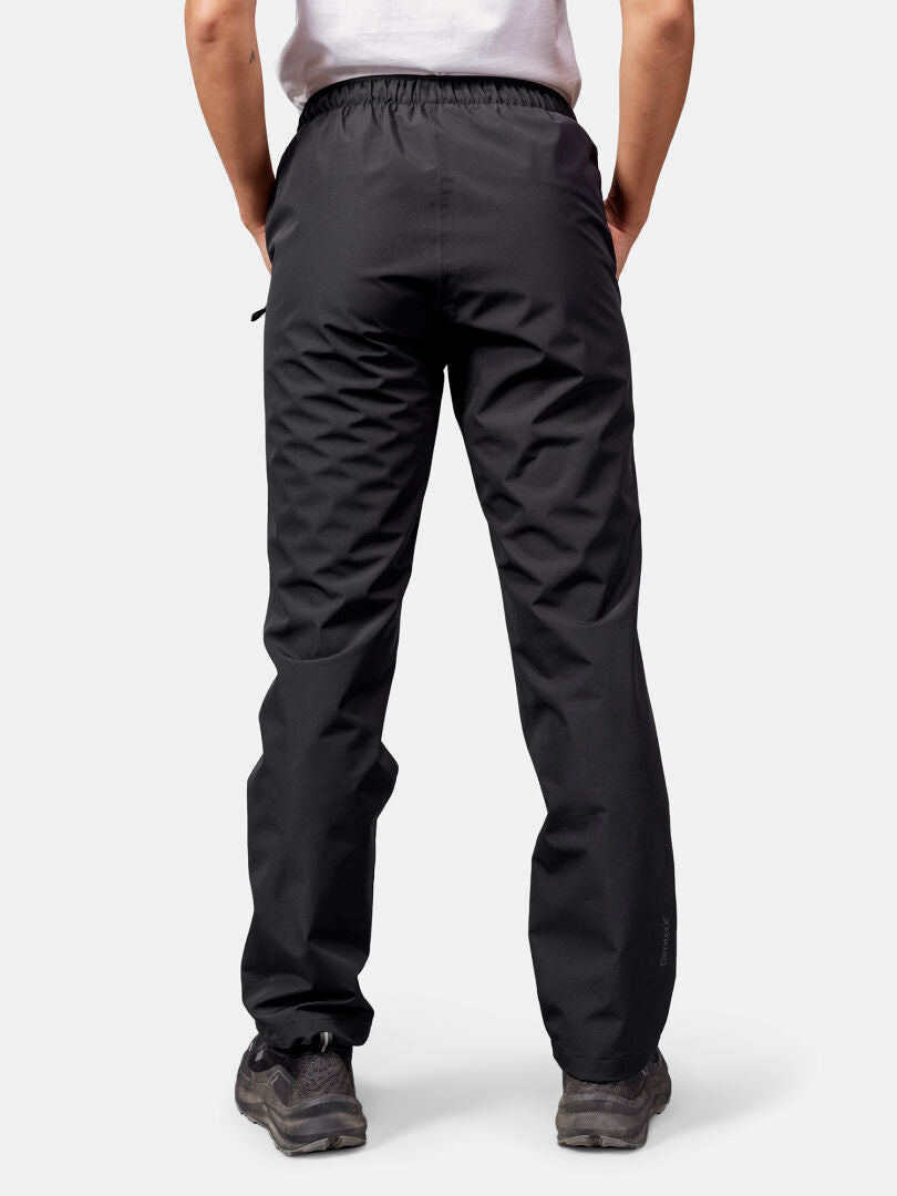 Person in black Halti Forter DX Shell Pants and hiking shoes, back to camera, against a plain background.