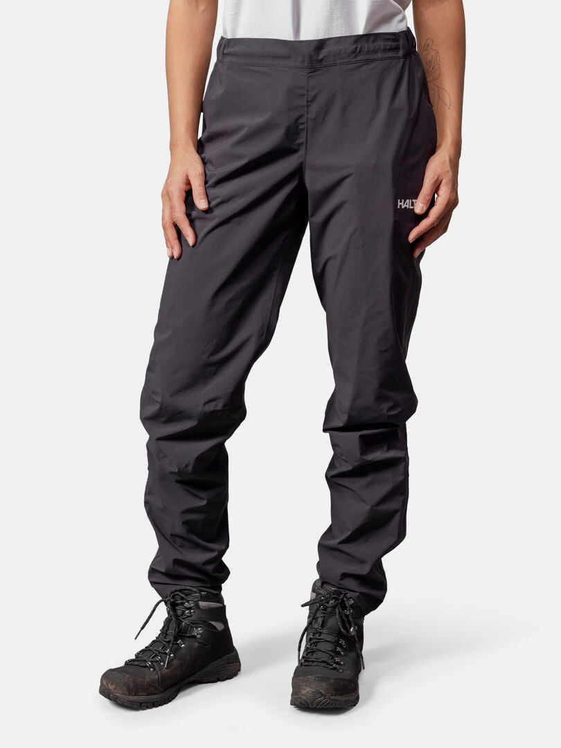 A person in Halti Pisarat 2,5L DX Shell Pants Women's stands against a plain background.