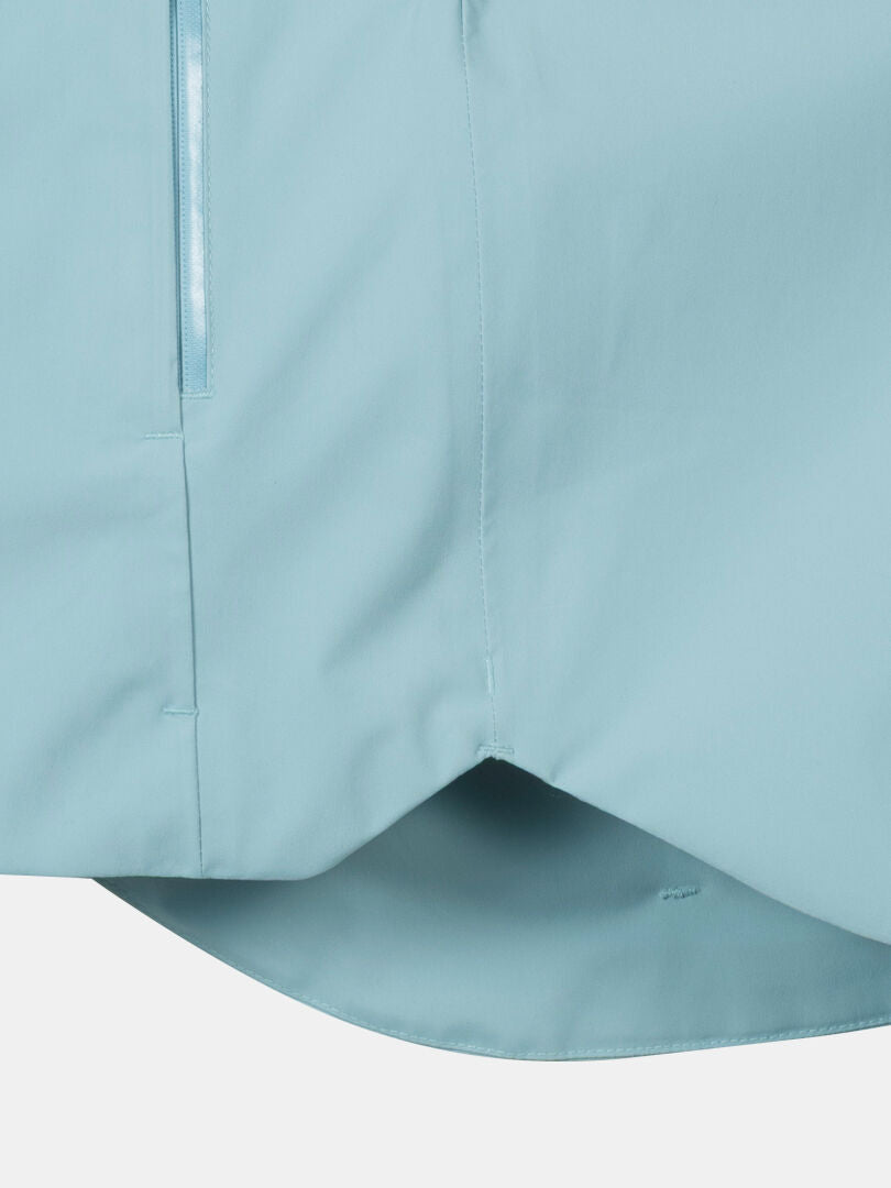 Close-up of the Halti Staala DrymaxX Shell Jacket Women's in light blue, with a vertical zipper and curved hem.