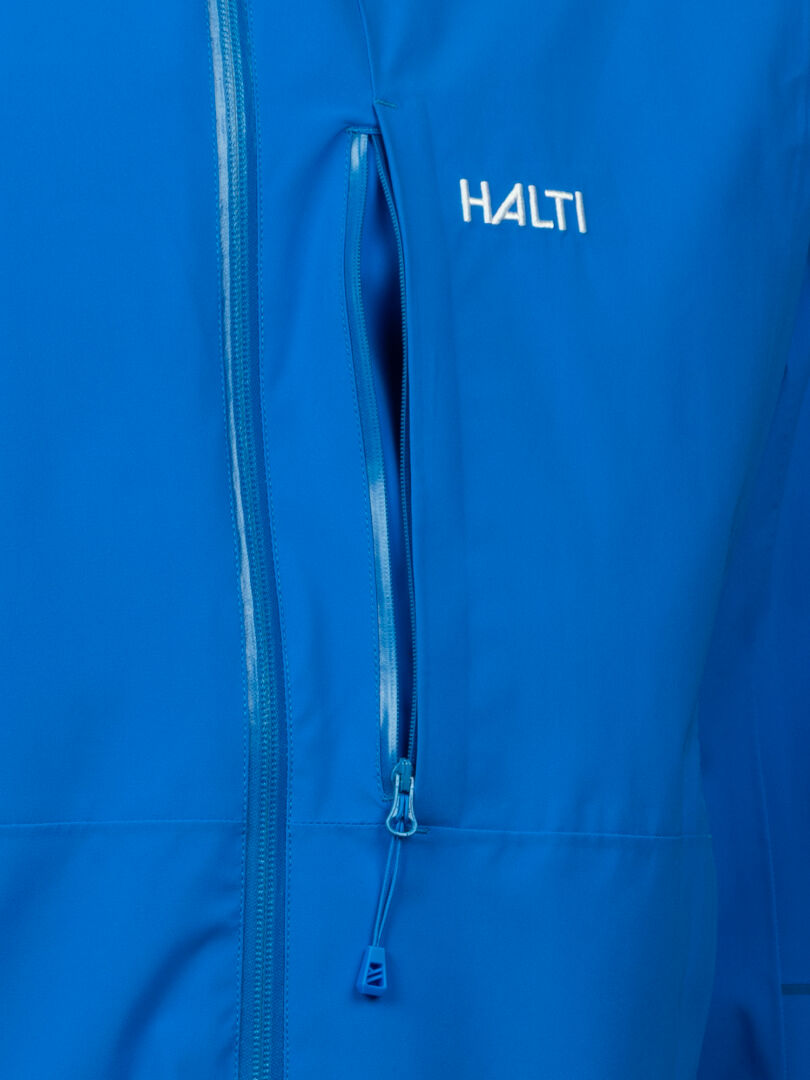 Close-up of the mens Halti Staala DrymaxX Shell Jacket, blue with a zip chest pocket and white Halti logo.