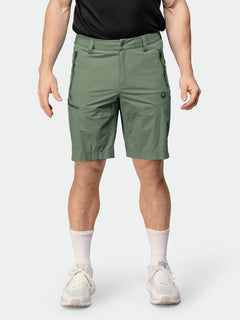 A man wears Halti Pallas Cool X-stretch Shorts, a black shirt, white crew socks, and white sneakers.