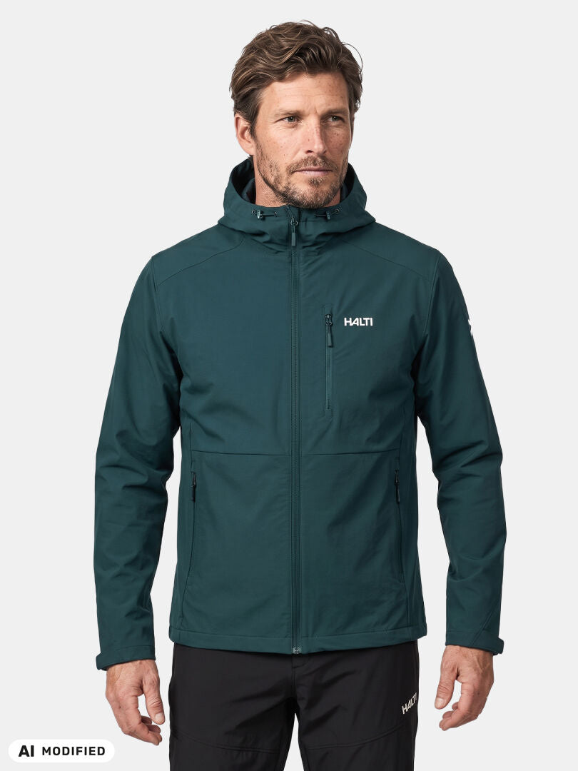 A man wears a teal Halti Finholma X-stretch Jacket, featuring windproof stretch fabric, against a white background.
