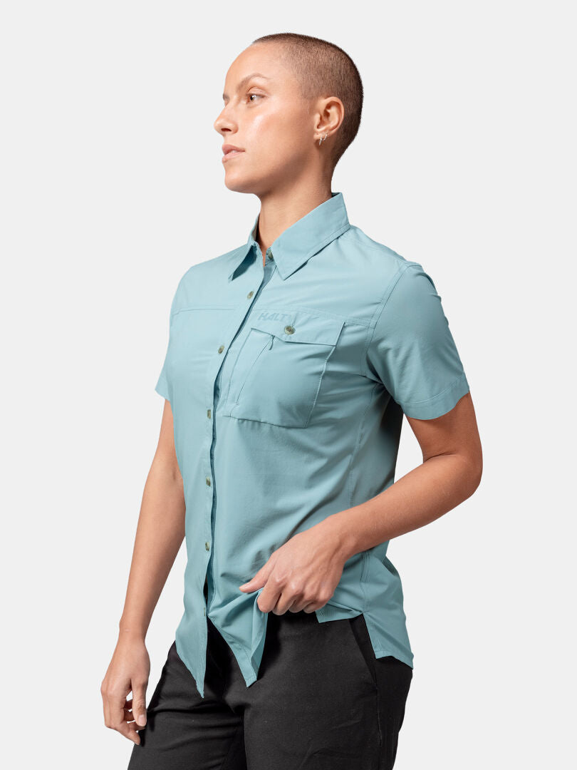 A person in a Halti Samoy Trekking Shirt Women's and dark pants stands against a plain background.
