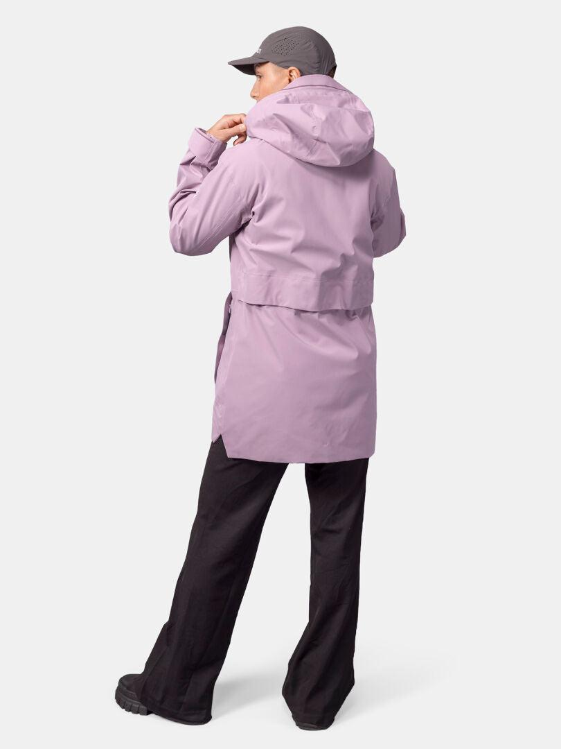 A person wears a light purple Halti Valaja DX Parka Jacket, black pants, and gray cap, back facing the camera.