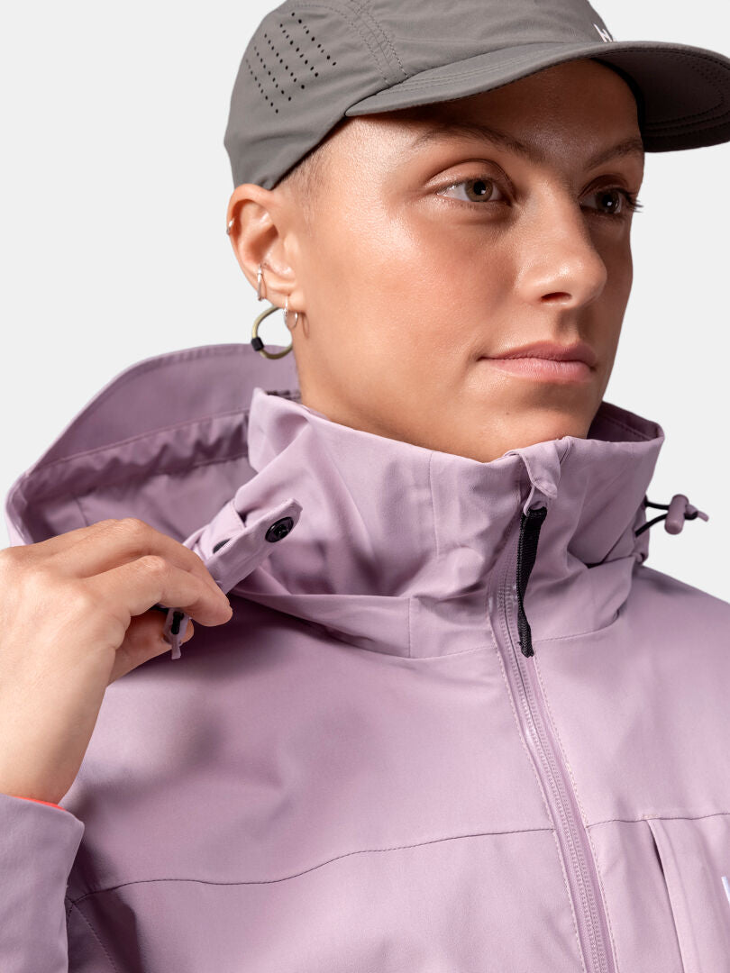 Woman in Halti Valaja DX Parka adjusts the collar, wearing a gray cap and facing slightly to the side.