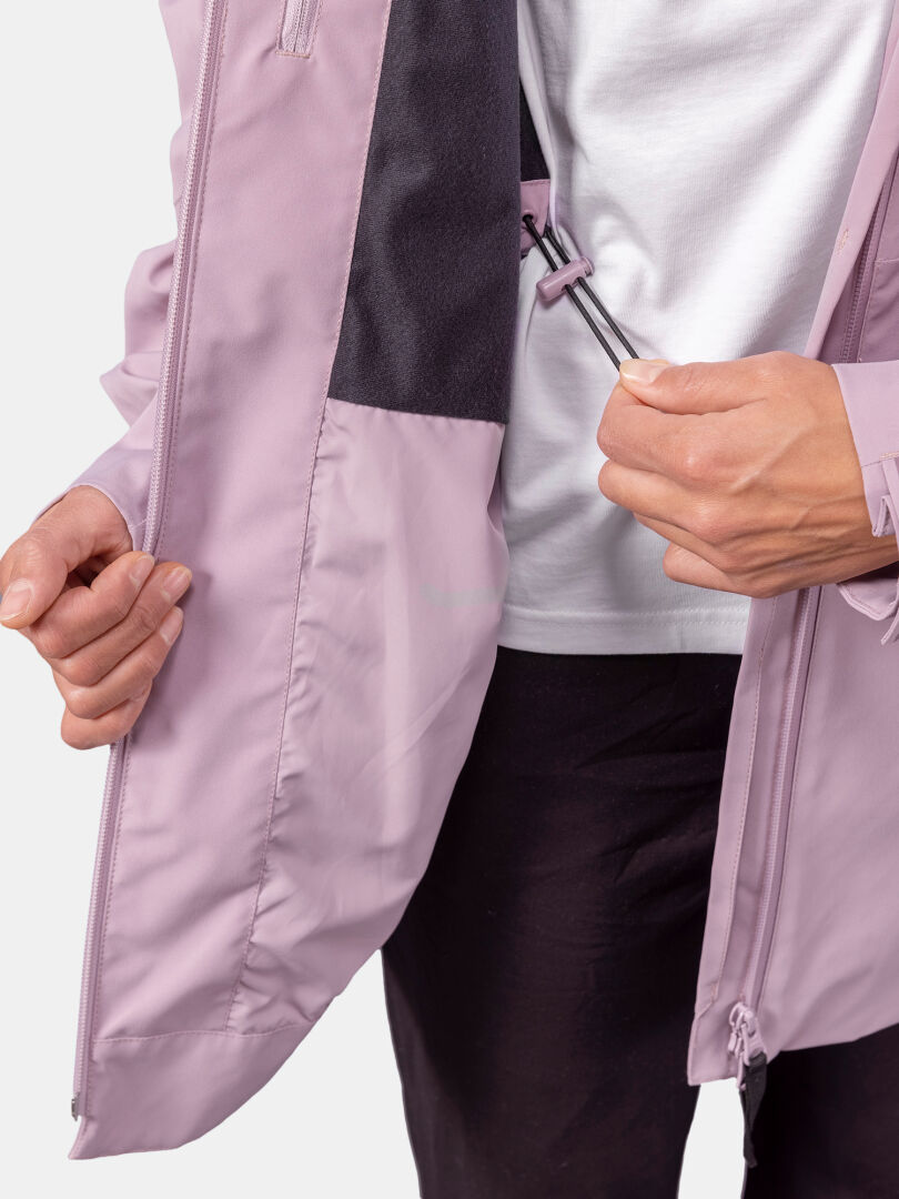 Person adjusting an elastic drawcord inside a light purple Halti Valaja DX Parka Jacket, over a white shirt and black pants.