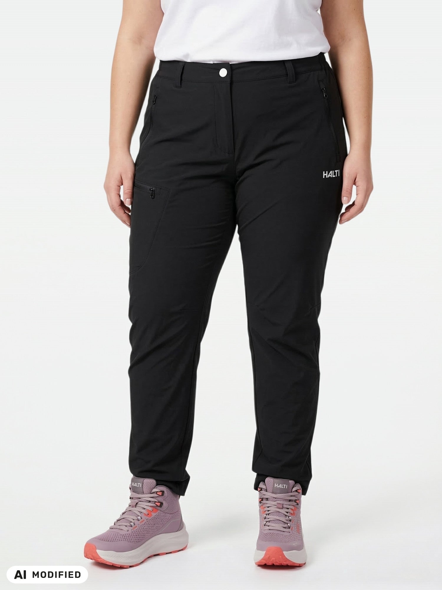 A person in Halti Pallas X-stretch Outdoor Pants Women's Plus, white shirt, and pink hiking boots stands on a white background.