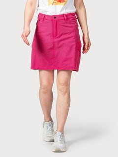 A person wears the Halti Reissu Stretch Skort for women, a white graphic tee, and sneakers against a plain background.