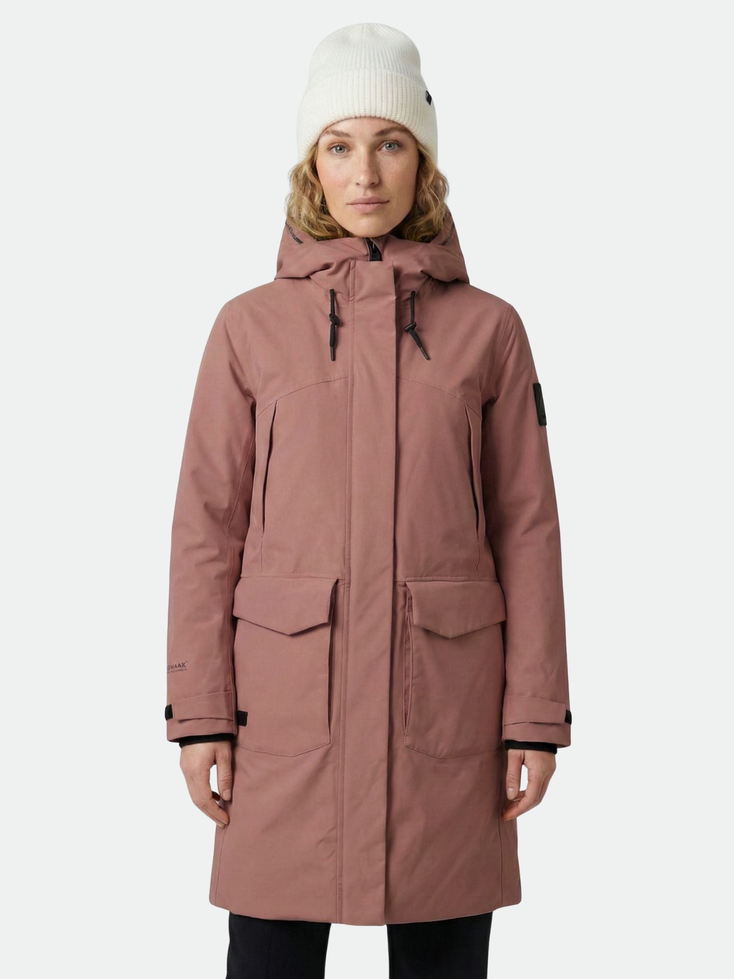 Someone wears the Halti Bergga Women's DrymaxX Winter Parka and a white beanie against a plain light background.