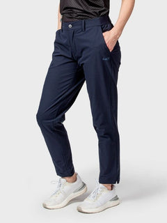 Model in Halti Drive Womens X-stretch Chinos and white sneakers stands with one hand in pocket against a plain background.