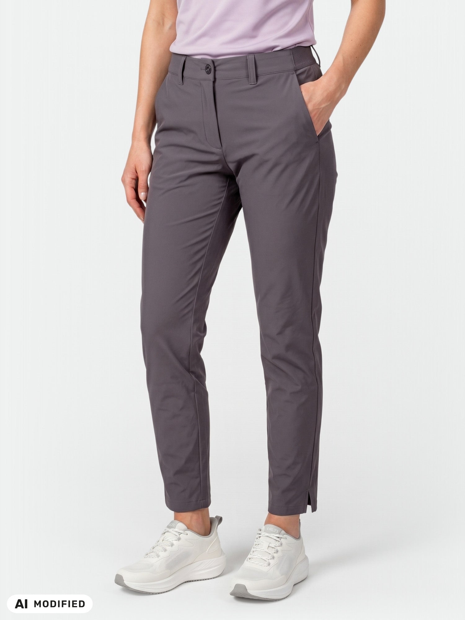Woman in gray Halti Drive X-stretch Chinos, light purple shirt, white sneakers, hands in pockets.