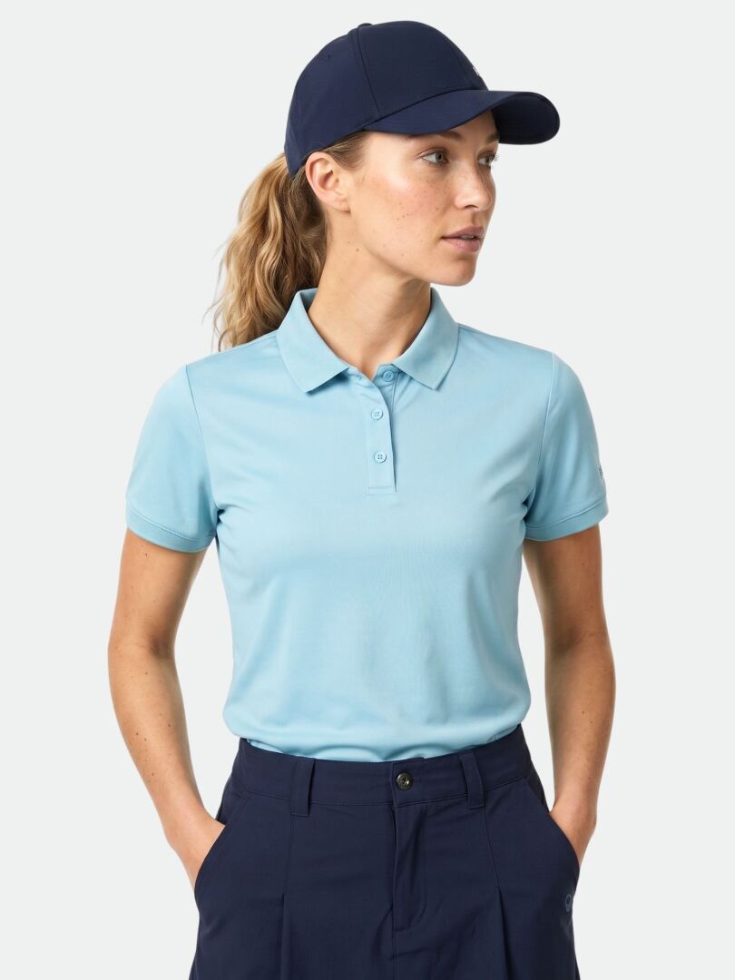 A woman wears the Halti Laine Technical Polo Shirt, made of breathable material, with her hands in her pockets.