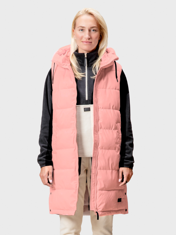 A woman wears the Halti Penger Puffer Vest over a black and white outfit, standing facing forward.