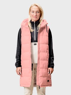 A woman wears the Halti Penger Puffer Vest over a black and white outfit, standing facing forward.