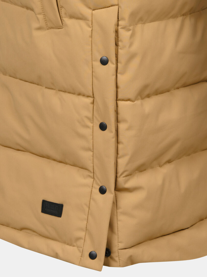 Close-up of Halti Penger Puffer Vest Women's in tan, featuring black snap buttons and a small black label near the hem.