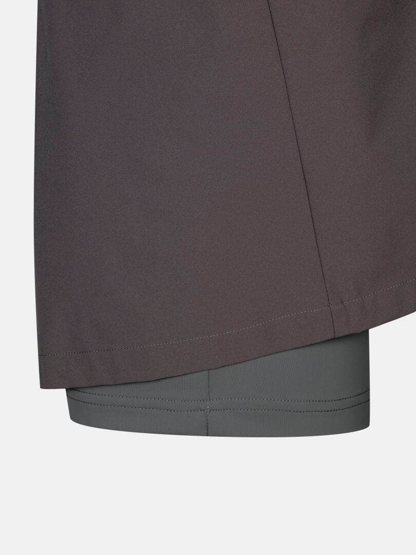 Close-up of Halti Drive X-stretch Skort Women's Plus in light gray, layered beneath a dark outer garment.