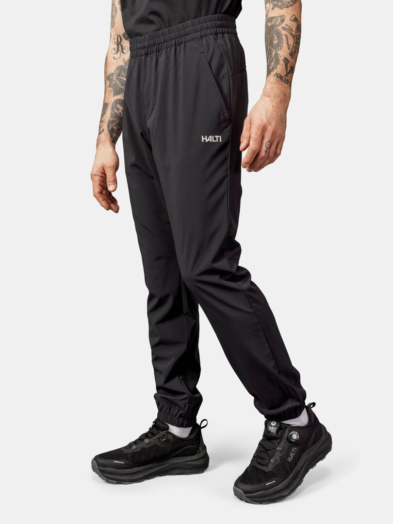 A man in Halti Grets Jogger Pants stands against a white background; quick-dry, stretch fabric.