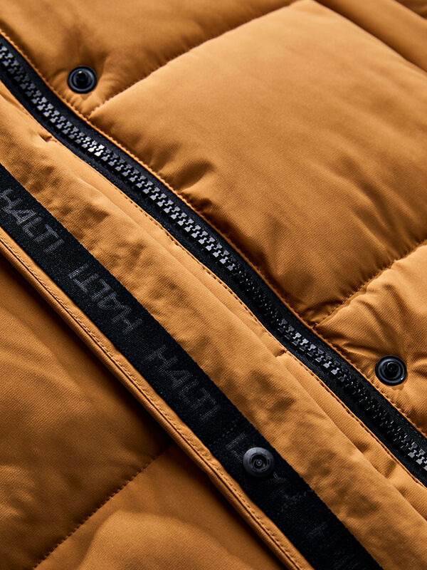 Close-up of Halti Brahe Puffer Long Winter Jacket Women’s in brown with zipper, black snaps, and black trim.