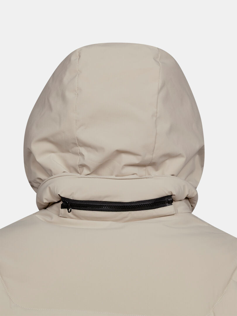 Close-up of Halti Brahe Puffer Long Winter Jacket Women’s in beige, with black zipper detail along the collar.