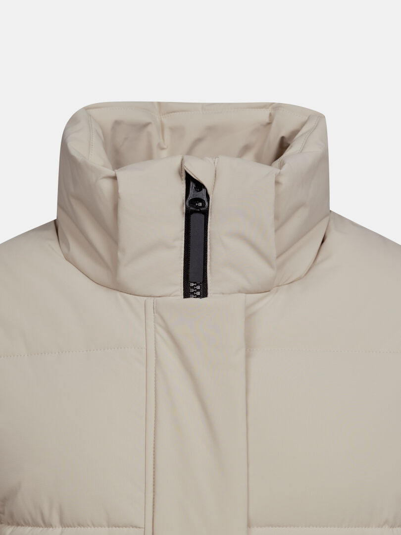 Close-up of the Halti Brahe Puffer Long Winter Jacket Women’s, a beige parka with high collar and short black zipper.