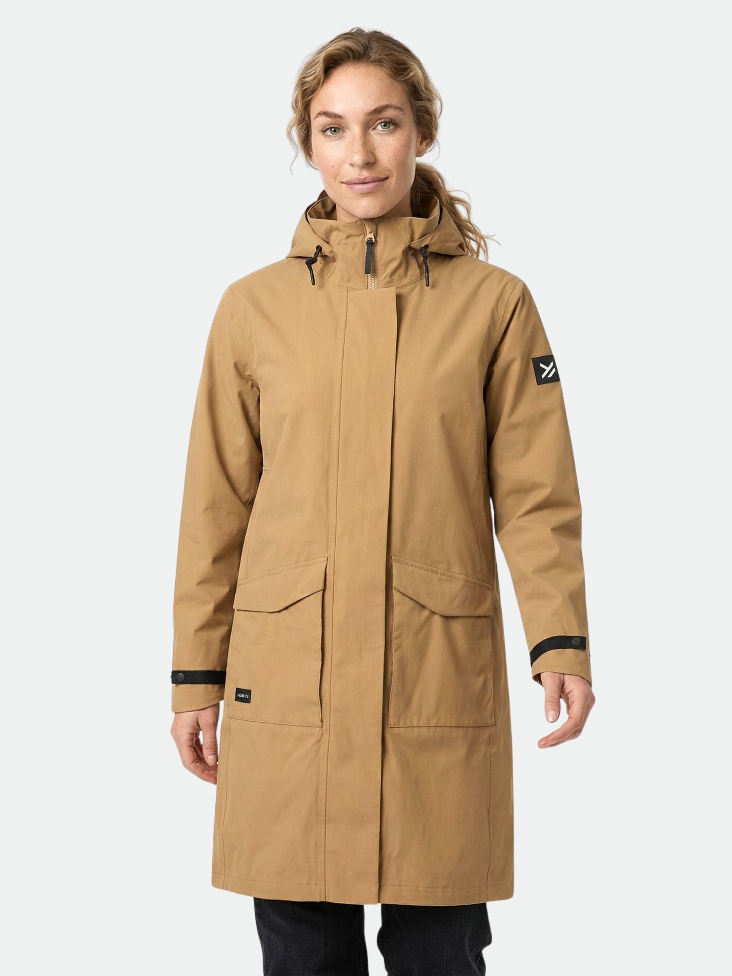 A woman wears the Halti Tokoi II DX Parka Jacket, made from recycled polyester, with large pockets and black trim.