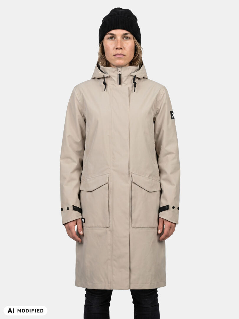 Woman wears Halti Tokoi II DX Parka and stands against a plain background, styled with a black beanie and pants.