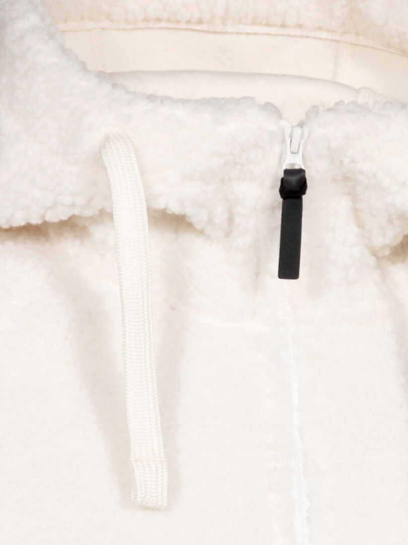 Close-up of Halti Lykky Fleece Pullover Womens in white recycled polyester, featuring a black zip pull tab and drawstring.