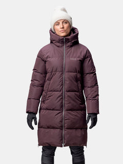 A woman wears the Halti Sammal Insulated Parka Jacket with DrymaxX®, a white beanie, and black gloves facing forward.