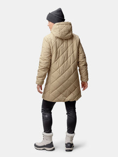 A person in a Halti Haapa Quilted Coat Jacket, dark pants, gray boots, and a gray beanie stands facing away.
