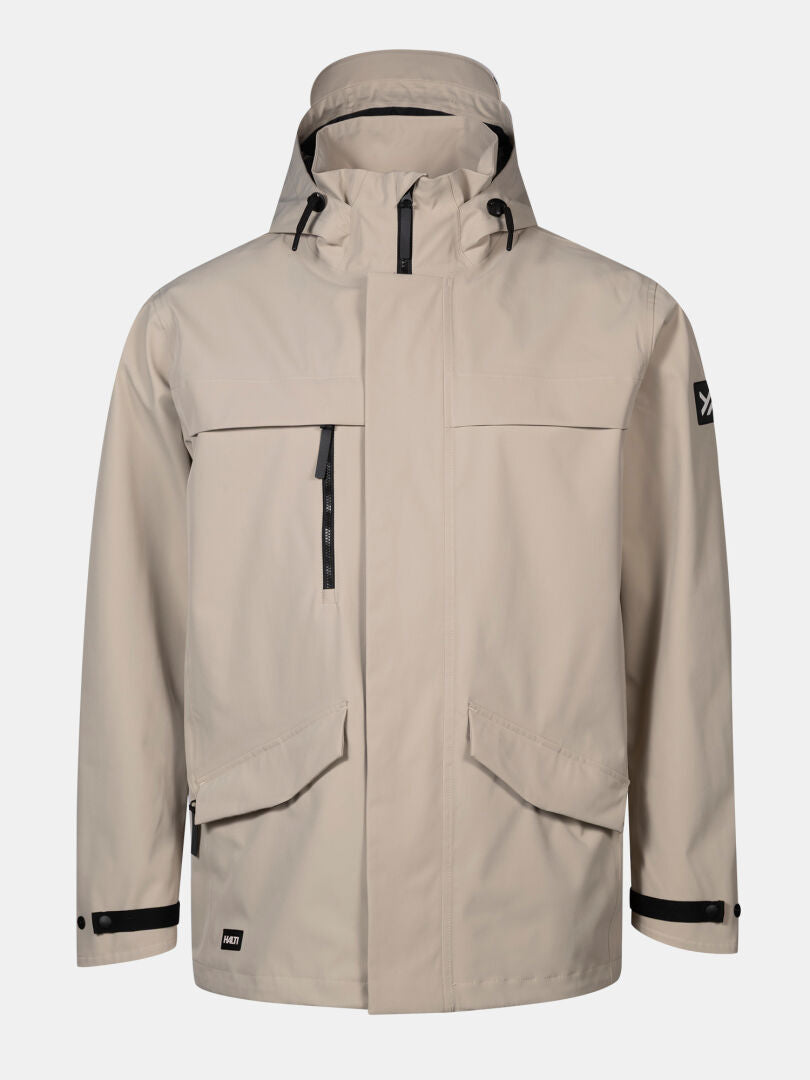 The Halti Tokoi DX Jacket Men's is beige, weatherproof, with black zippers, pockets, and adjustable cuffs.