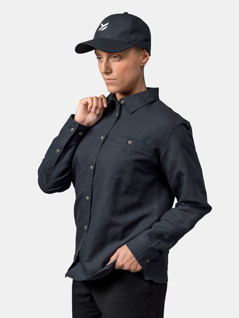 Woman in Halti Notsgi Longsleeve Shirt and dark cap, standing against a plain light background.