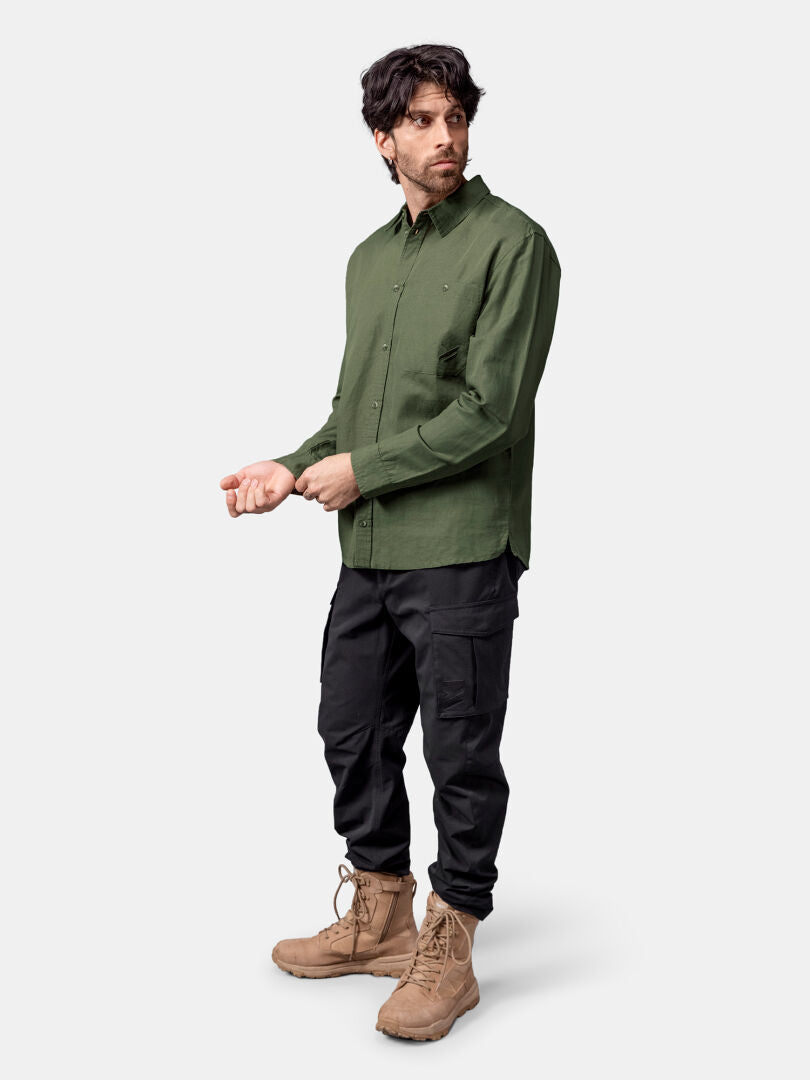 A man wears the Halti Notsgi Longsleeve Shirt Men's in green, black cargo pants, and tan lace-up boots.