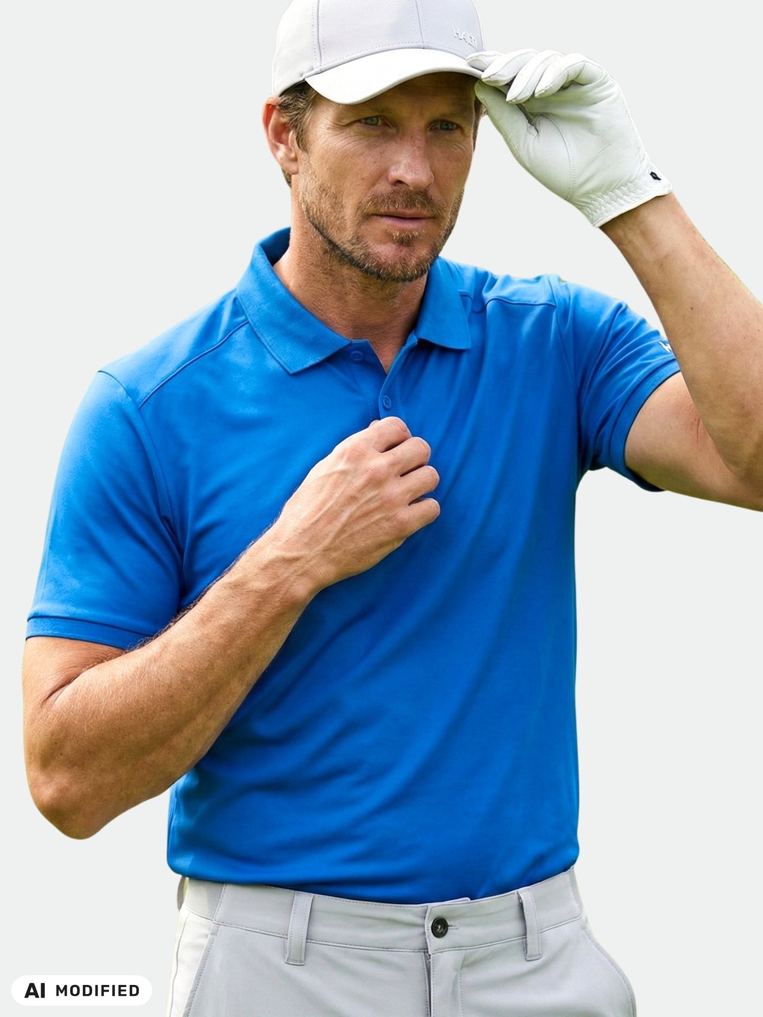 Man in a blue Halti Aridi Technical Polo and white cap adjusts his hat, wearing a white glove, isolated background.