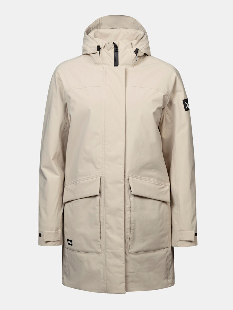 Halti Kortteli DX Women’s parka, beige, insulated, with front pockets, buttoned cuffs, and left sleeve patch logo.