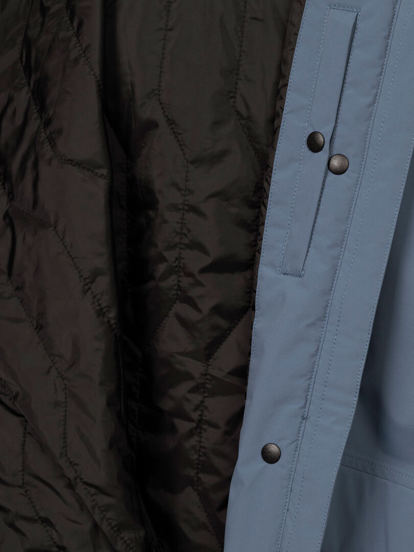 Close-up of Halti Kortteli DX Women’s Insulated Parka: black quilted lining, light blue shell, black snap buttons.