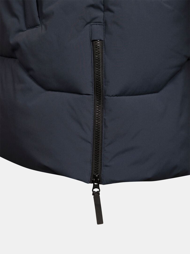 Close-up of Halti Brahe Puffer Parka Men’s in dark blue, black zipper partly open, showing weather-resistant texture.