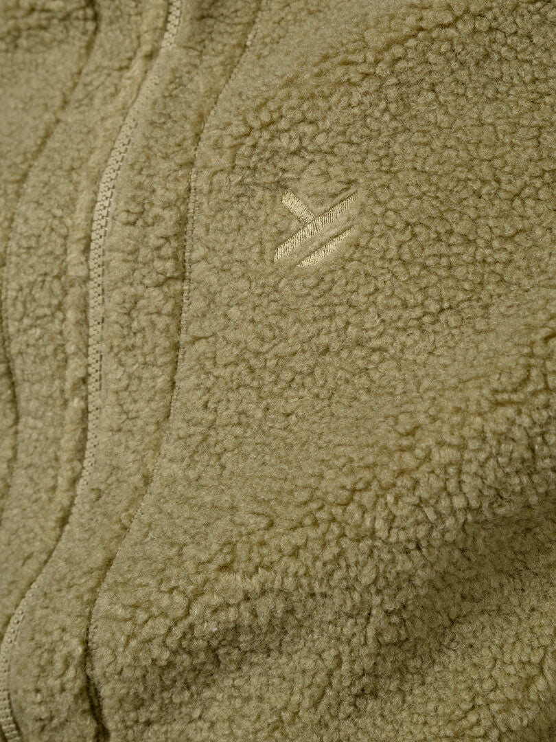 Close-up of Halti Lykky Fleece Vest Unisex in tan, with zipper, small logo, and recycled polyester sustainable design.