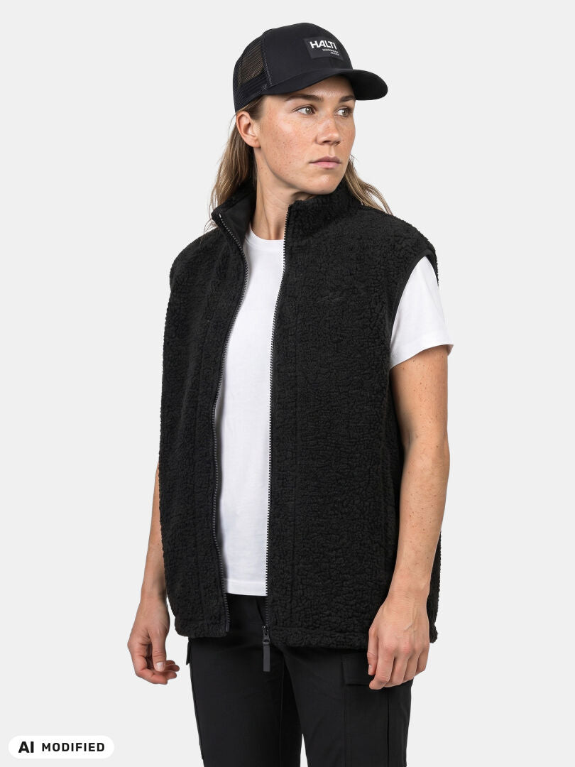 Person in a black Halti Lykky Fleece Vest Unisex faces left against a plain light background.