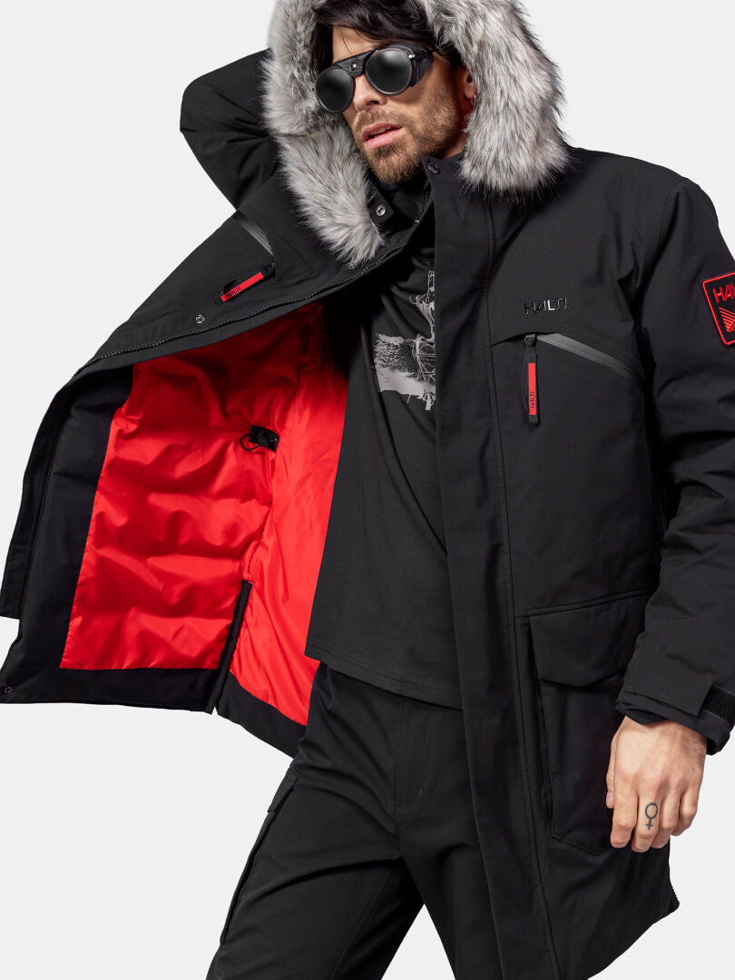 A man models the Halti 1976 Down Parka Unisex by Halti, showing its red lining and wearing sunglasses.