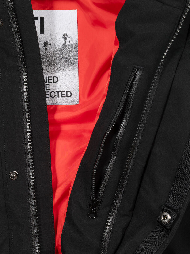 Close-up of the Halti 1976 Down Parka Unisex in black with red lining, interior zip pocket, and Halti patch label.