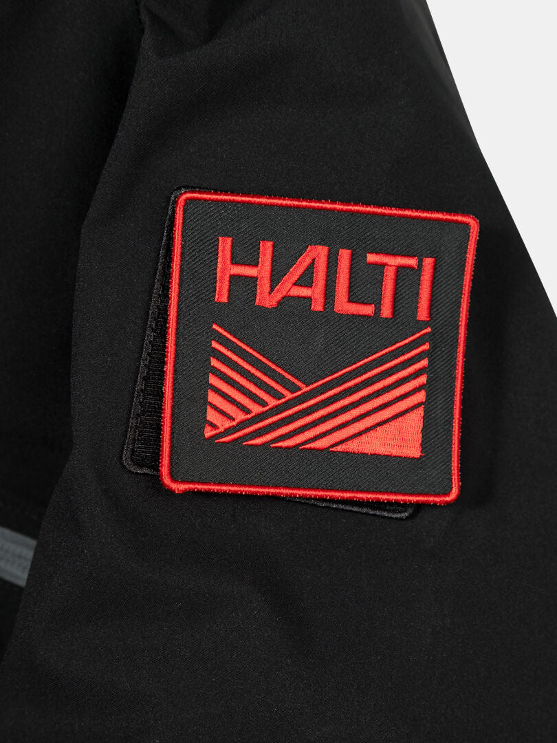 A black fabric patch with red Halti text is sewn onto the Halti 1976 Down Parka Unisex.
