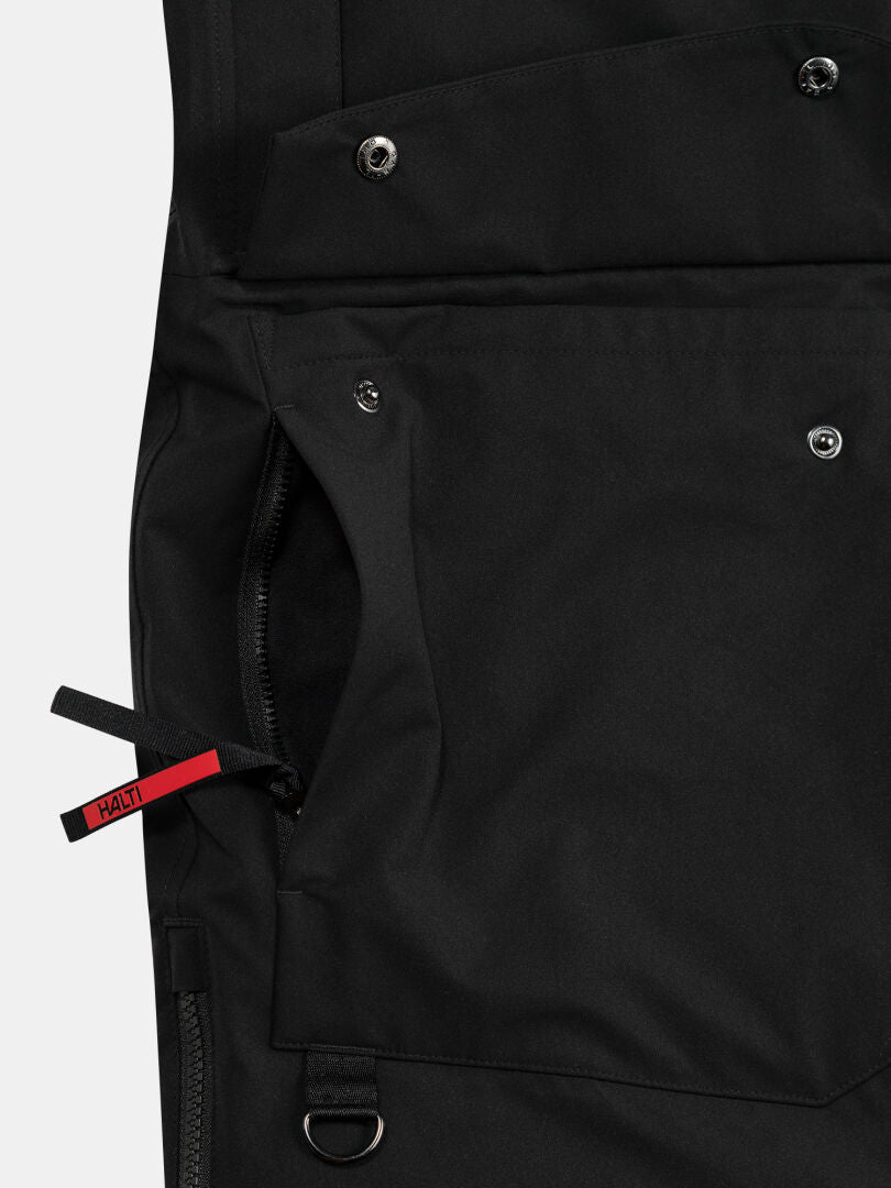 Close-up of the Halti 1976 Down Parka Unisex, featuring a zip pocket, snap buttons, and red Halti-branded pull tab.
