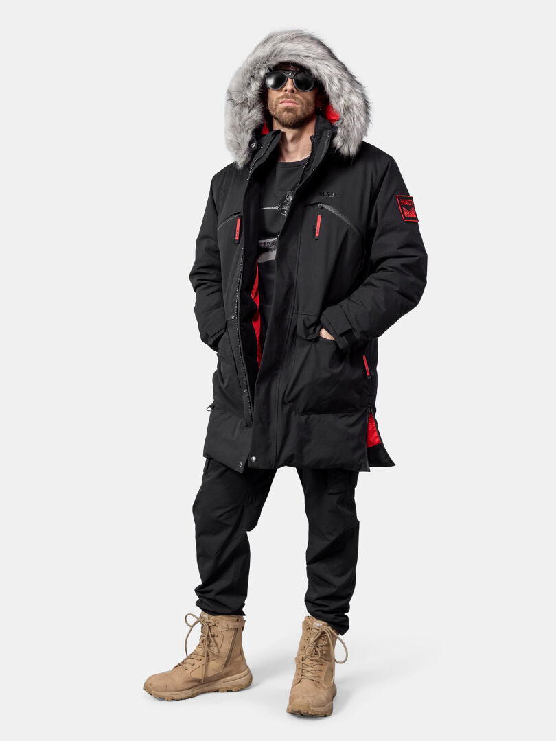 Person wearing a Halti 1976 Down Parka Unisex, black pants, tan boots, sunglasses, and a black shirt.