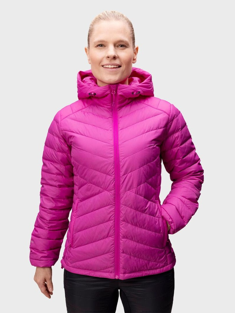 Woman in Halti Huippu Down Jacket stands with hands in pockets against a plain light background.