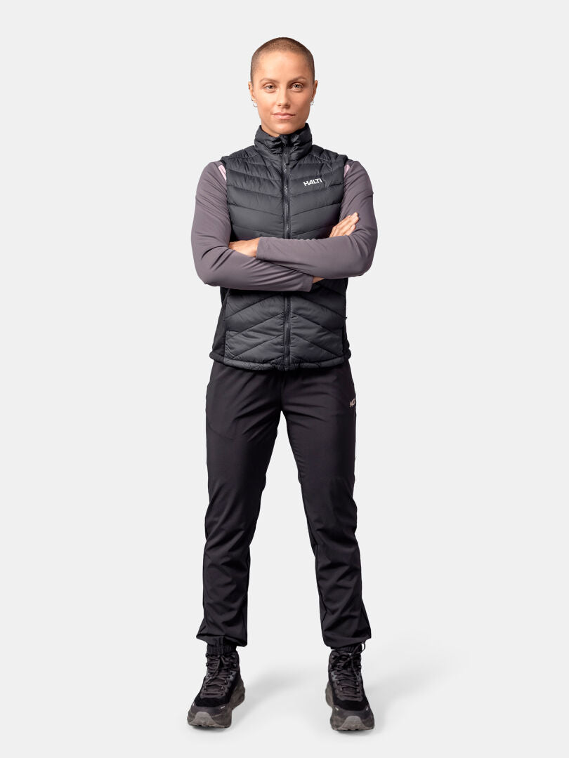 Woman with short hair faces forward, arms crossed, in Halti Huippu Hybrid Down Vest made of Pertex Quantum Ripstop.