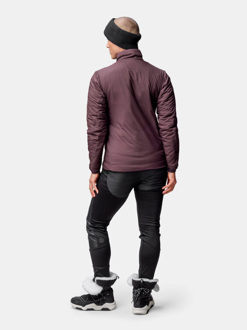 A woman in a maroon Halti Haave Primaloft Insulation Jacket, black pants, and winter boots stands facing away.