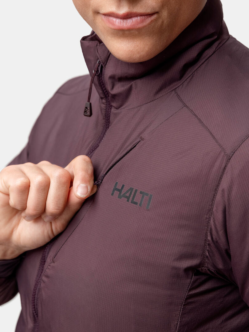 A person zips up a maroon Halti Haave Primaloft Insulation Jacket Women's with the logo on the chest.