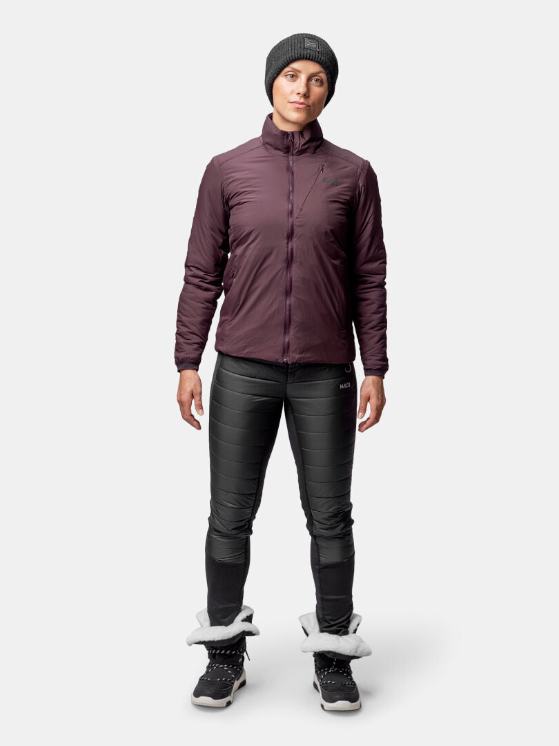 A woman faces forward wearing the Halti Haave Primaloft Insulation Jacket, black pants, and fur-trimmed winter boots.