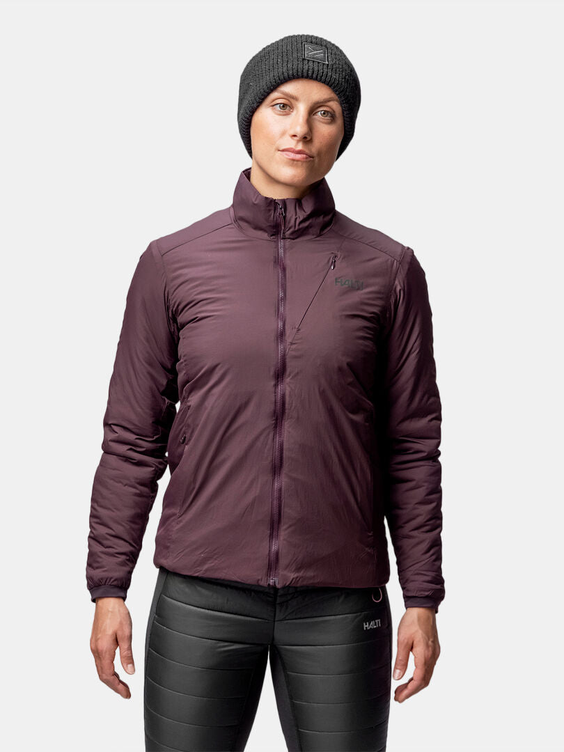 Person wearing a black knit beanie, Halti Haave Primaloft Insulation Jacket Women's in maroon, and black pants.