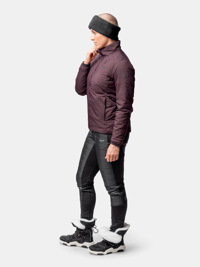 A person wears the Halti Haave Primaloft Insulation Jacket for women, black leggings, winter boots, and a headband.